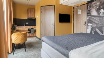 Overzicht van de Deluxe Studio in Hotel Marktstad met keuken, tweepersoons king size bed, flatscreen televisie en tafel met twee stoelen