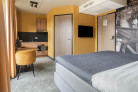 Overzicht van de Deluxe Studio in Hotel Marktstad met keuken, tweepersoons king size bed, flatscreen televisie en tafel met twee stoelen